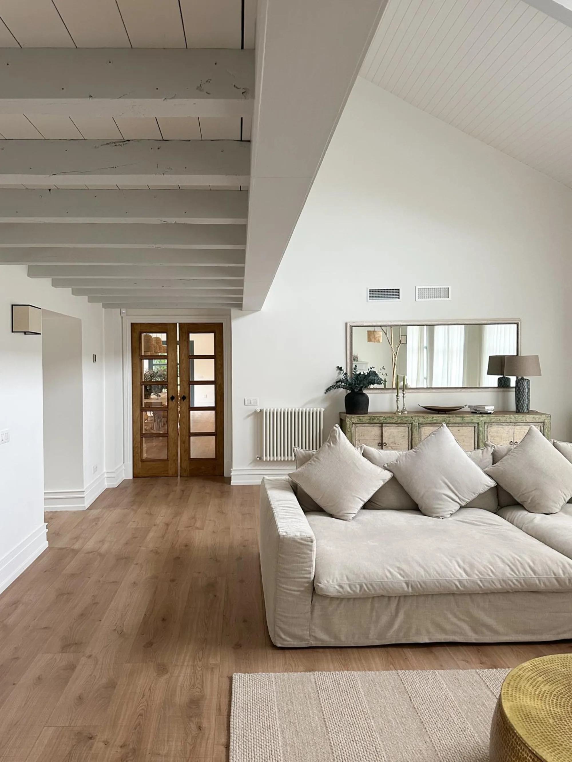 Salon con vigas blancas en Dario Aparicio por Santayana Home